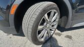 Close-up of a car tire and alloy wheel with the fender and orange side marker in view.