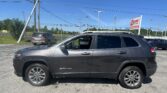 Gray SUV parked in a dealership lot on a sunny day, with tall power lines and an EZ Loan Auto Sales sign in the background.