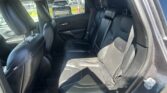 Rear interior of a black leather SUV with headrests and visible seat belts