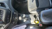 Interior of a car showing the driver and front passenger seats, center console with gear shifter, and a yellow bottle near the seat on the right side.