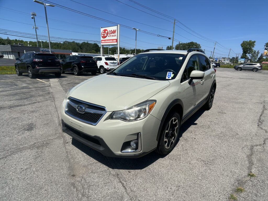 Beige SUV in a parking lot with other vehicles and an EZ Loan sign in the background on a sunny day