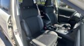 Inside view of a car with black cloth seats and red contrast stitching, front seats and center console visible.