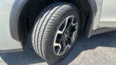 Close-up of a car tire and alloy wheel mounted on a gray SUV, showing the wheel well and fender.