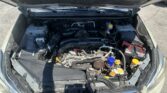 Front section of a car with the hood raised, exposing the engine bay and various components like the battery, coolant reservoir, and air intake hoses