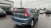 Blue Honda SUV in a wet parking lot with a Toyota dealership in the background on a rainy day