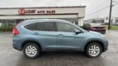 Blue SUV parked in front of a used-car dealership with an 'E-Z LOAN AUTO SALES' sign on the building and other cars in the lot background.
