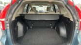 Rear hatch open on a green SUV, exposing the beige cargo area with a retractable cover and folded rear seats visible ahead.