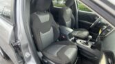 Interior of a car: front driver and passenger seats with black fabric, gray inserts, and white stitching, center console visible.