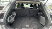 Open SUV trunk showing cargo area with rear seats upright and front seats visible, ready for loading personal belongings.