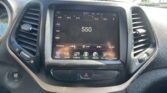 Center touchscreen in car showing FM radio at 550 with surrounding app icons and climate controls visible on the dashboard edge