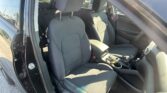 Front seats and center console of a car interior viewed from the open driver’s side door in daylight
