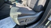 Interior of a car showing the front seats, center console with gear shifter, and a paper floor mat underfoot on the driver-side area.