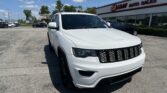 White SUV parked in a lot in front of the EZ LOAN AUTO SALES dealership sign.