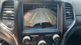 Car rearview camera display showing parking lot with green, yellow, and red guiding lines; text reads 'Check Entire Surroundings' at top.