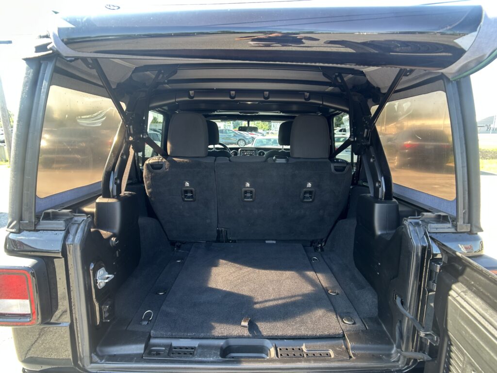 Open tailgate view of a black SUV with folded third-row seats and spacious cargo area.