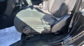 Interior view of a car's front passenger area: black seats, center console, gear shifter, and seat belt visible.