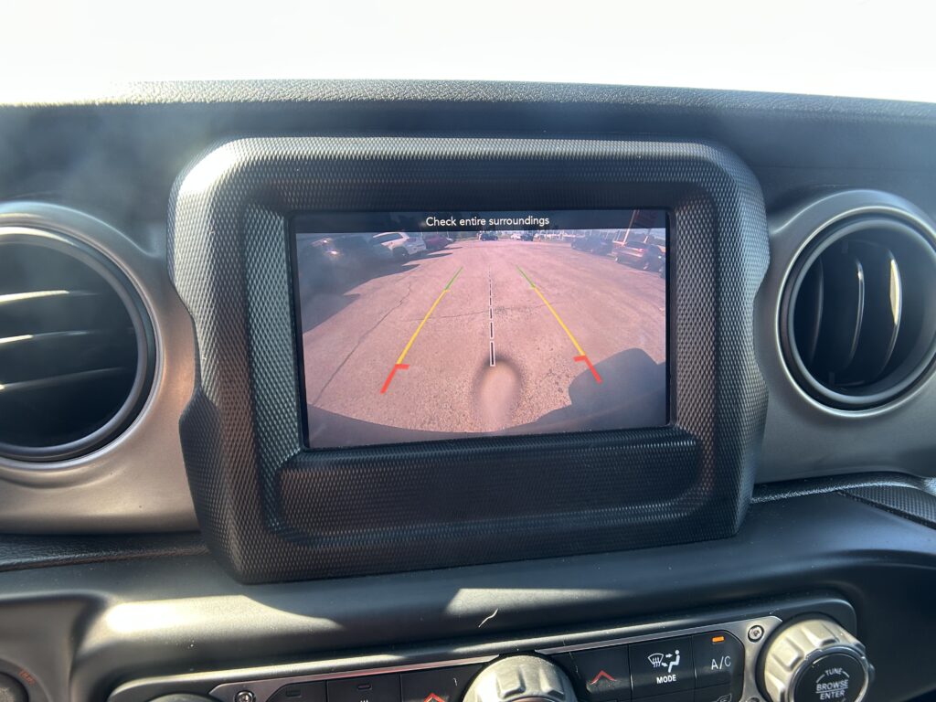 In-car display showing the rearview camera view with guiding lines for parking in a lot.