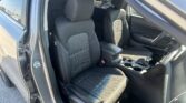 Interior view of a car showing two front seats with black fabric and white stitching, center console visible