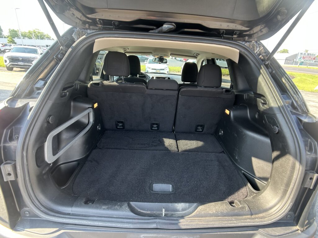 Open SUV hatch showing spacious cargo area with rear seats upright, parked lot visible outside