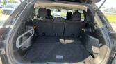 Open SUV hatch showing spacious cargo area with rear seats upright, parked lot visible outside