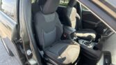 Front interior of a car with black fabric seats, headrests, and center console visible through an open door.