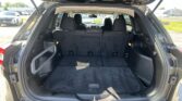 Open SUV rear hatch showing spacious cargo area with folded third-row seats ready for storage.