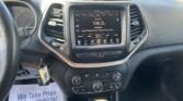 Center touchscreen shows 106.5 FM country radio with dashboard and steering wheel in view.
