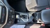 Interior of a Jeep showing the center console with gear selector, climate controls, and cup holder; black hexagonal floor mat with 'Jeep' logo visible.