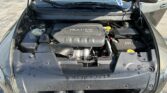 Engine bay of a car with the black 'MULTIAIR 2.4L' engine cover and the hood open in the foreground.