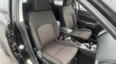 Front interior of a black car showing driver and passenger seats with red stitched fabric, center console, and gear shifter visible.