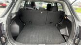 Open SUV hatchback showing a spacious cargo area with rear seats upright and headrests, wet exterior with raindrops on the edges of the trunk.