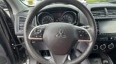 Driver's perspective of a car interior focusing on the steering wheel and instrument cluster with speedometer and tachometer visible