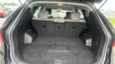 Open SUV hatch showing a spacious cargo area with third-row seats upright and headrests visible in front of the cargo space.