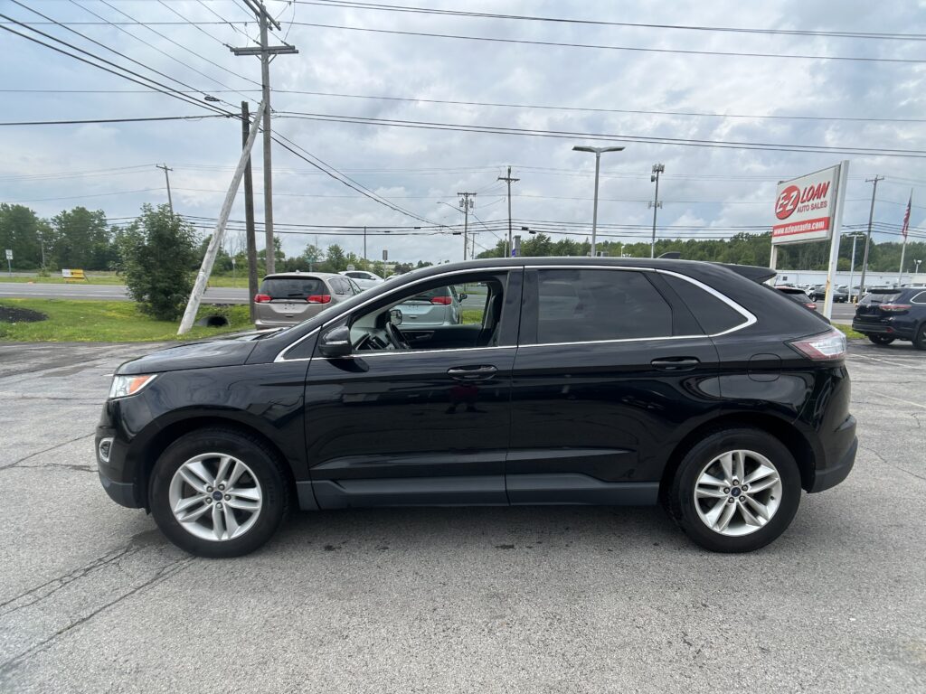 Black SUV parked in a lot with a leaning utility pole and EZ Auto Sales sign in the background under a cloudy sky.