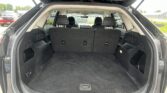 Cargo area of an SUV with rear seats upright and ample trunk space visible, black interior and open tailgate