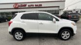 White SUV parked in front of the E-Z Loan Auto Sales dealership sign.