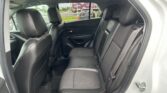 Backseat of a black leather SUV with two headrests and visible seat belts in a spacious interior guarded by stitched seams on the seats.