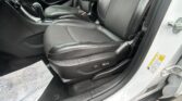 Interior of a car showing black leather front seats, center console, and door panel viewed from the passenger side.