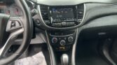 Interior of a car dashboard: steering wheel on the left, analog gauges, and a center touchscreen displaying audio settings surrounded by vents and control buttons.