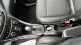 View of the car's front cabin: dark leather seats, center console, gear selector, and cup holders visible from above.