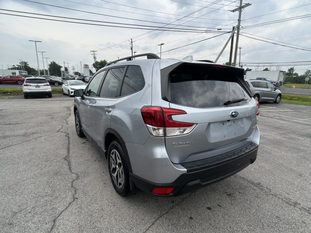 Silver Subaru SUV in a parking lot, shown from the rear-side angle with other cars and power lines in the background (informational).