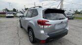 Silver Subaru SUV in a parking lot, shown from the rear-side angle with other cars and power lines in the background (informational).