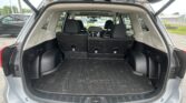 Open rear hatch showing cargo area of a Subaru SUV with folded third-row seats and a rubber mat labeled 'SUBARU' in the floor.