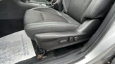 Car interior focusing on the front passenger seat area with dark fabric upholstery, center console, and Subaru-branded door sill visible near the floor.