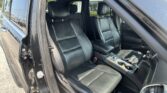 Interior of a black SUV with dark leather seats and center console visible from the open door.
