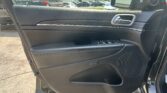 Car interior: inside of a vehicle door with door handle, window controls, and speaker grill visible.