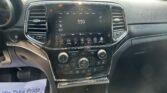 Center console touchscreen showing radio set to 550 AM with climate and media controls around it in a parked car interior.