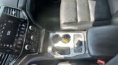 Interior of a car focusing on the front passenger seat and center console with cupholders and controls visible on the console surface
