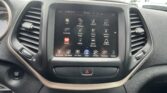 In-car touchscreen showing app icons such as Aha, Assist, Climate, and Controls on the center console.