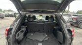 SUV with open tailgate showing folded floor mats in the cargo area behind rear seats